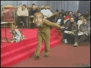 a man with a beard is dancing on a red carpet in front of a crowd that is watching