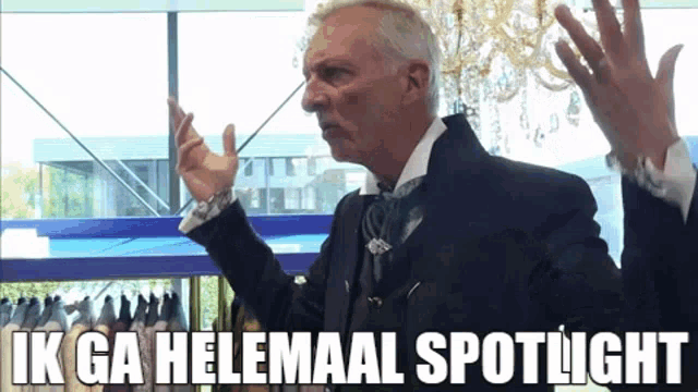 a man in a suit and tie says ik ga helemaal spotlight in a foreign language