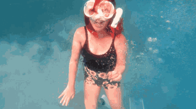 a woman wearing a mask and goggles is underwater