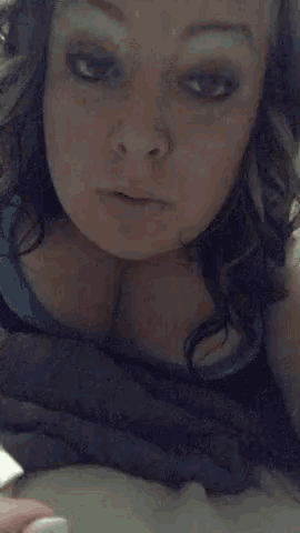 a close up of a woman 's face with a blue shirt on