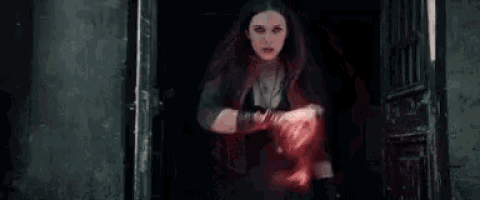 a woman is standing in a doorway holding a red light in her hands .