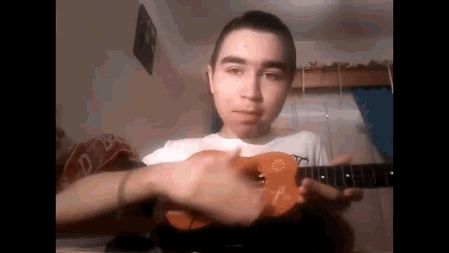 a young man is playing a guitar in a bedroom