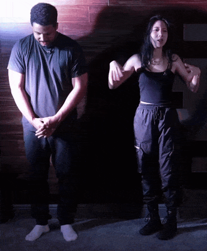 a man and a woman are standing next to each other in the dark