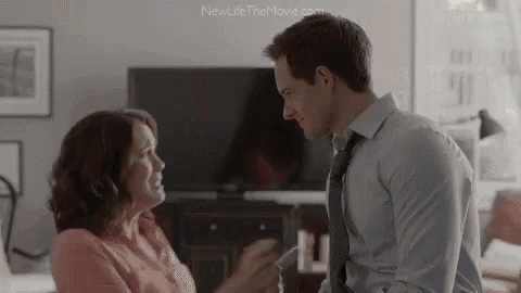 a man and a woman are kissing in a living room .