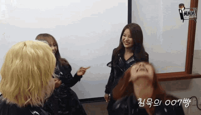 a group of women are standing in front of a white board that says ' mmm ' on it