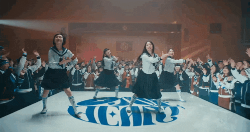 a group of girls are dancing in front of a logo that says ' heat ' on it