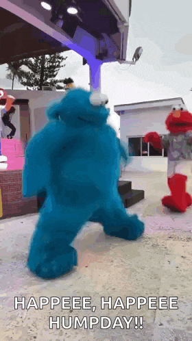 elmo and cookie monster are dancing on a stage and the caption says happeee happeee humpday !!