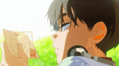 a boy is holding a piece of paper with a heart on it that says " i love you "