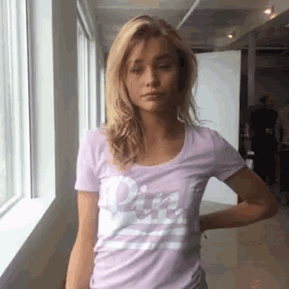 a woman wearing a purple shirt that says pink