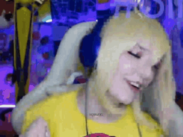 a woman with blonde hair is wearing headphones and a yellow shirt that says " i love you " on it