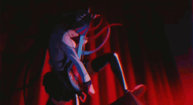 a person is sitting on a stage in a dark room holding a book in their hand .