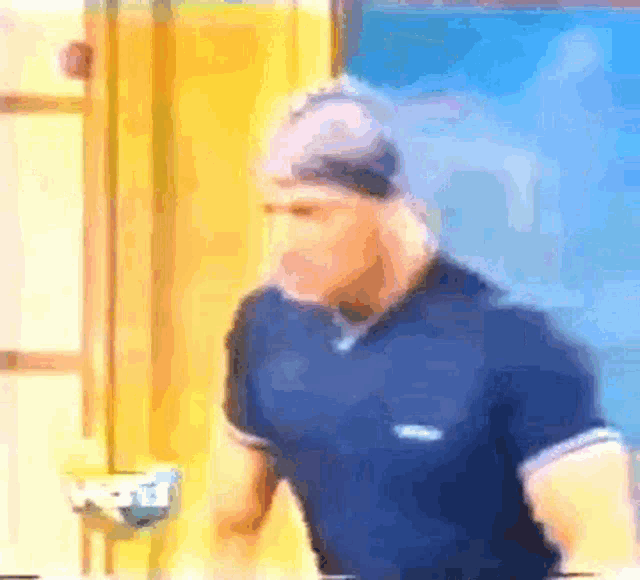 a blurry picture of a man wearing a blue shirt and a headband