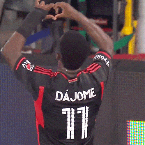 a soccer player named dajome is making a heart with his hands