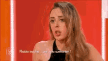 a woman in a black top is talking on a red background