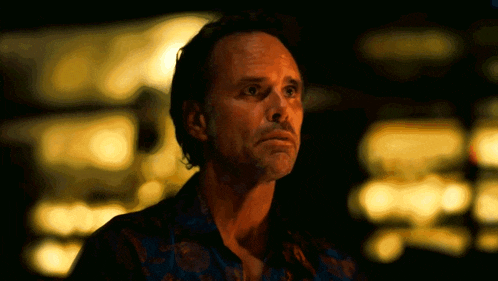 a close up of a man 's face with a blurry background of lights