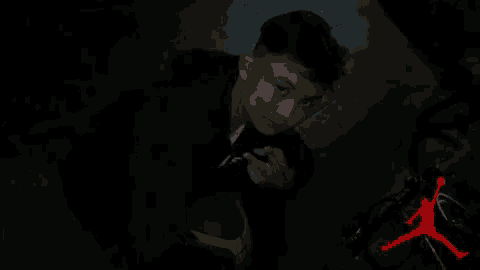 a person is standing in the dark with a red air jordan logo in the background