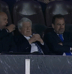 three men in suits and ties are sitting in the stands