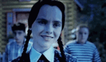 a woman with pigtails is smiling in a dark room .