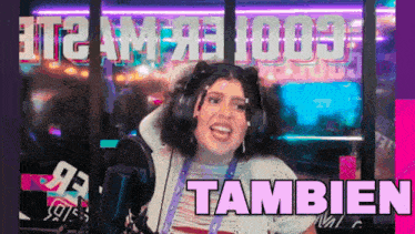 a woman wearing headphones is smiling in front of a microphone and the word tambien is on the bottom right
