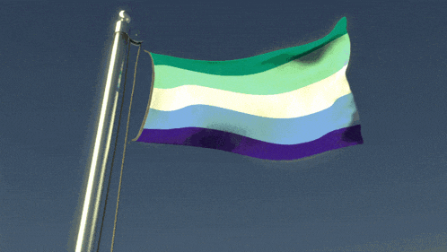 a green purple and white flag flies in the wind