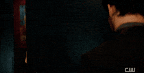 a close up of a man 's face with a cw logo in the background