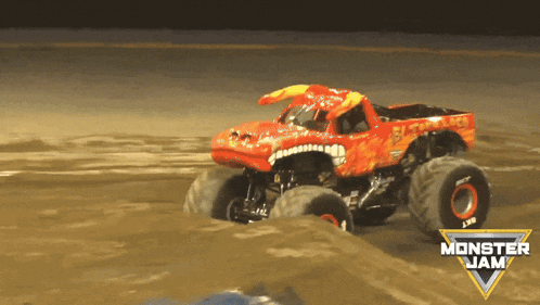 a monster jam truck is driving on a dirt track