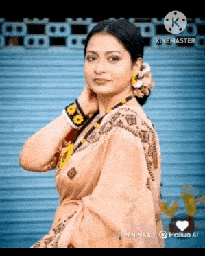 a woman in a saree with a flower in her hair is standing in front of a blue wall