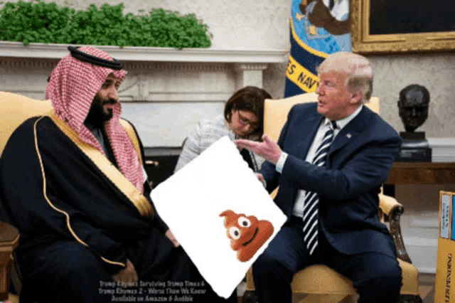 a man holding a piece of paper with a poop face on it sits next to donald trump