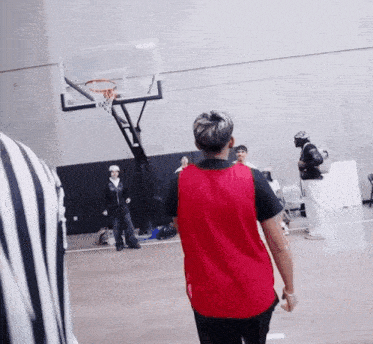a man in a red shirt is playing basketball