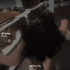 a woman is laying on the floor with her head on a table in a room .