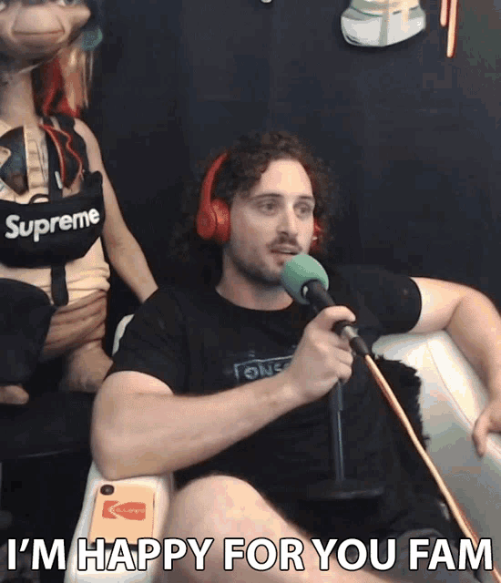 a man wearing headphones and a shirt that says supreme