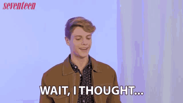 a young man in a brown jacket is saying wait i thought