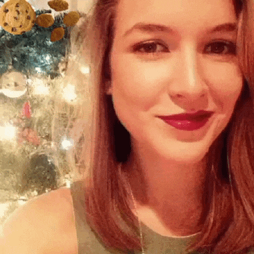 a close up of a woman 's face with a christmas tree behind her