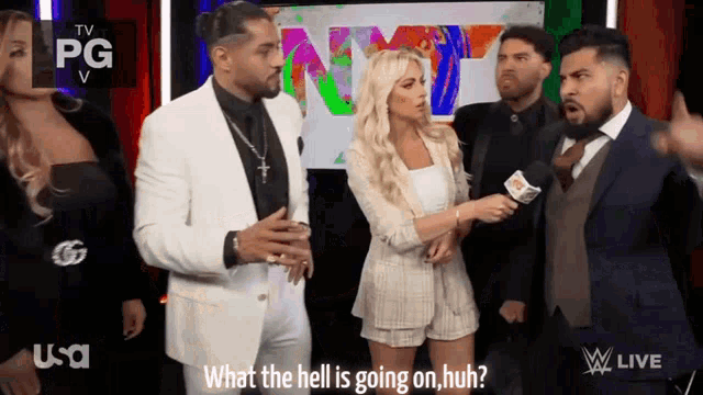 a group of people standing in front of a screen that says ' what the hell is going on huh ' on it