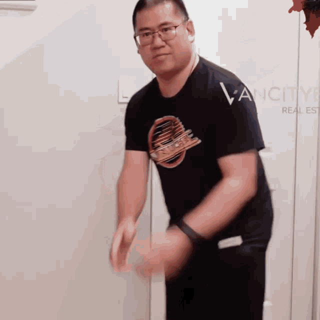 a man wearing glasses and a vancouver canucks shirt