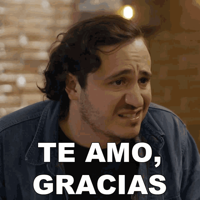 a man in a denim jacket says te amo gracias in white letters