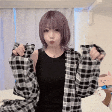 a girl with purple hair is wearing a black tank top and a black and white plaid shirt