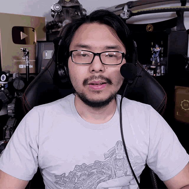 a man wearing glasses and headphones is sitting in front of a sign that says 311