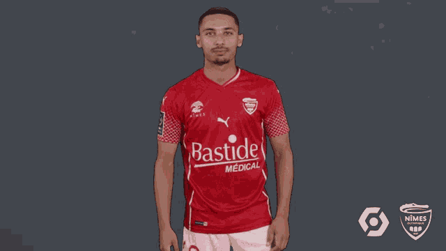 a man wearing a red shirt that says basil medical