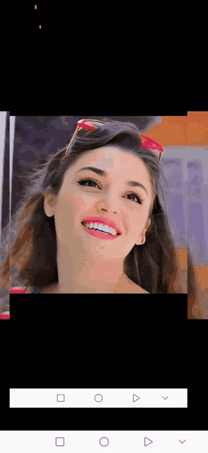 a close up of a woman 's face with sunglasses on smiling .