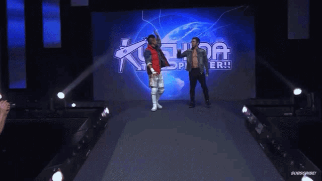 two wrestlers are giving each other a high five in front of a king of the ring sign