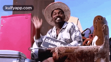 a man wearing a straw hat is sitting on a couch .