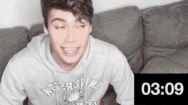 a young man wearing a sweatshirt that says ' university ' on it