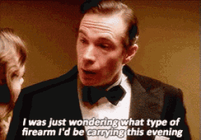 a man in a tuxedo and bow tie is talking to a woman ..