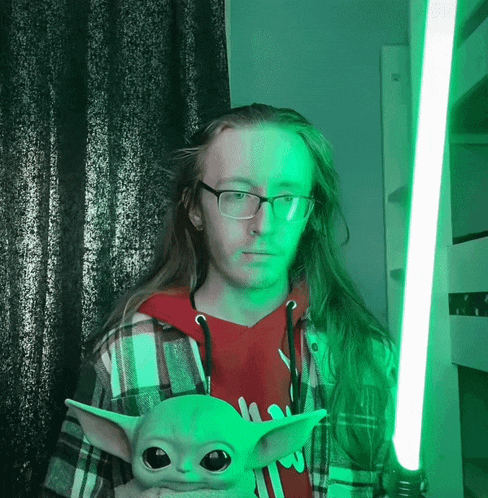 a man in a plaid shirt is holding a green light saber and a stuffed animal