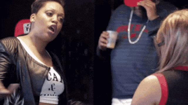 a woman wearing a crop top that says ca on it is talking to another woman