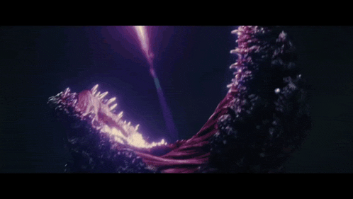 a purple light is coming out of a monster 's mouth in the dark .