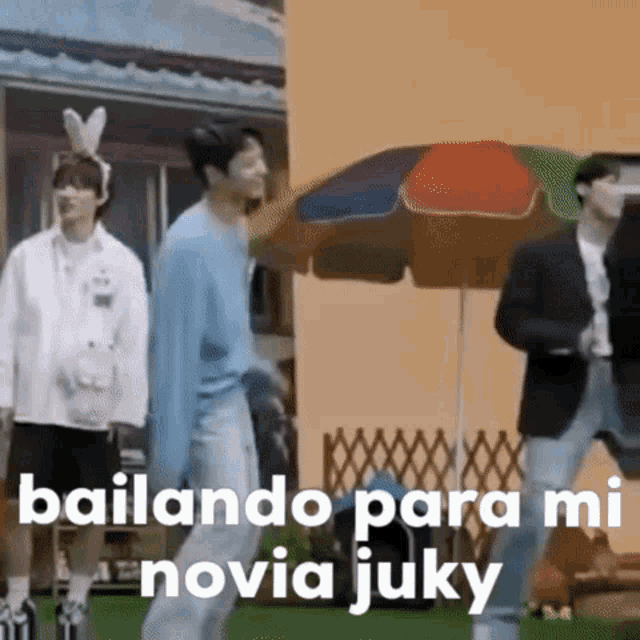 a group of men are dancing under an umbrella in a video .