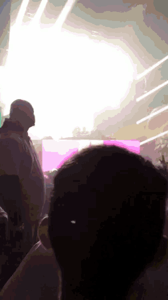 a man stands in front of a stage with a purple light behind him