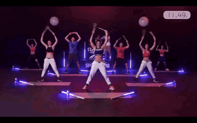a group of people dancing in front of a reebok sign
